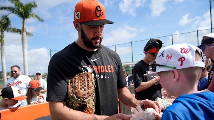 Orioles right-hand pitcher Grayson Rodriguez signs an autograph for fan Charlie Brose, 11, from Pittsburgh, Pennsylvania. The Baltimore Orioles held their first full-squad workout of the 2025 spring training season on Tuesday, Feb. 18th in Sarasota, Florida.