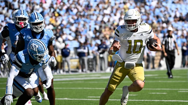 Oct 12, 2024; Chapel Hill, North Carolina, USA; Georgia Tech Yellow Jackets quarterback Haynes King (10) runs as North Carolina Tar Heels defensive back Antavious Lane (1) defends in the second quarter at Kenan Memorial Stadium. Mandatory Credit: Bob Donnan-Imagn Images
