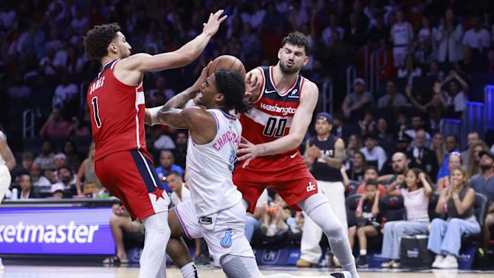 Apr 13, 2025; Miami, Florida, USA;  Washington Wizards guard Colby Jones (1) and  forward Tristan Vukcevic (00) defend Miami Heat guard Josh Christopher (8) during the second half at Kaseya Center. Mandatory Credit: Rhona Wise-Imagn Images