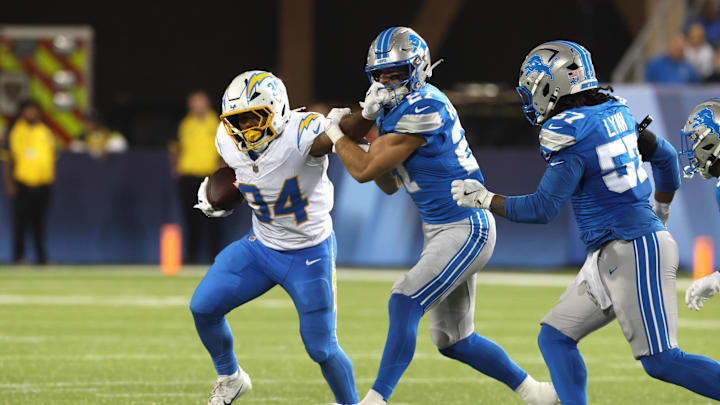 Jul 31, 2025; Canton, Ohio, USA; Los Angeles Chargers running back Jaret Patterson (34) runs against Detroit Lions safety Ian Kennelly (27) in the second half  at Tom Benson Hall of Fame Stadium. Mandatory Credit: Charles LeClaire-Imagn Images