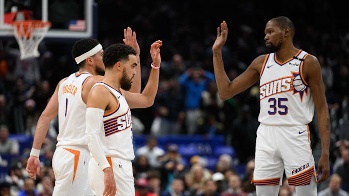 Jan 16, 2025; Washington, District of Columbia, USA; Phoenix Suns guard Tyus Jones (21), guard Devin Booker (1), and forward Kevin Durant (35) celebrate during the fourth quarter against the Washington Wizards at Capital One Arena. Mandatory Credit: Reggie Hildred-Imagn Images