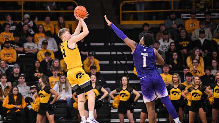 Feb 22, 2025; Iowa City, Iowa, USA; Iowa Hawkeyes guard Josh Dix (4) shoots the ball as Washington Huskies forward Great Osobor (1) defends during the first half at Carver-Hawkeye Arena. Mandatory Credit: Jeffrey Becker-Imagn Images