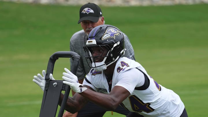 Baltimore Ravens coach Chuck Pagano and safety Malaki Starks work on drills during training camp. Baltimore Ravens coach Chuck Pagano and safety Malaki Starks work on drills during training camp.