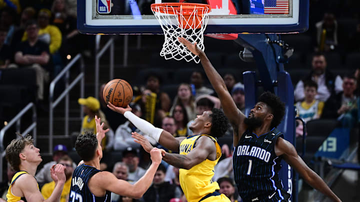Apr 11, 2025; Indianapolis, Indiana, USA; Indiana Pacers guard Bennedict Mathurin (00) shoots the ball under Orlando Magic forward Jonathan Isaac (1) during the second half at Gainbridge Fieldhouse. Mandatory Credit: Marc Lebryk-Imagn Images