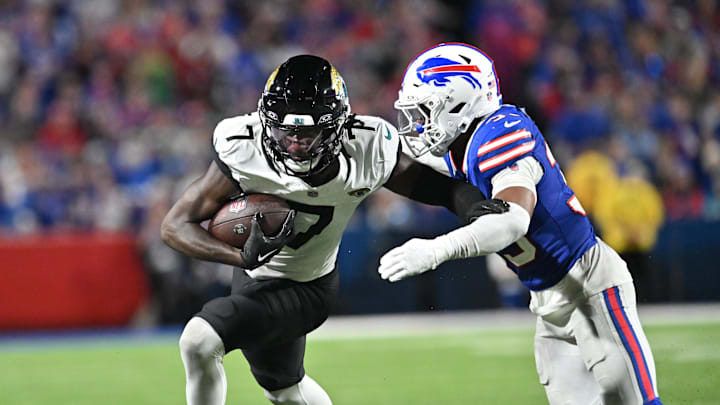 Sep 23, 2024; Orchard Park, New York, USA; Jacksonville Jaguars wide receiver Brian Thomas Jr. (7) tries to avoid a tackle by Buffalo Bills cornerback Cam Lewis (39) after making a catch in the third quarter at Highmark Stadium. Mandatory Credit: Mark Konezny-Imagn Images