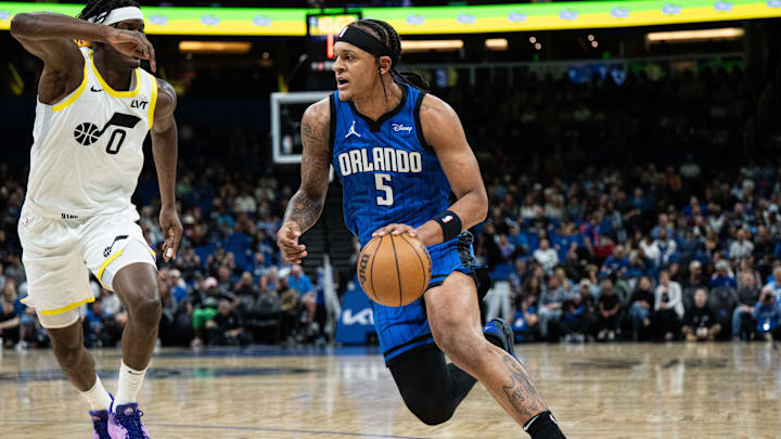 Feb 29, 2024; Orlando, Florida, USA; Orlando Magic forward Paolo Banchero (5) dribbles the ball against Utah Jazz forward Taylor Hendricks (0) in the first quarter at Kia Center. Mandatory Credit: Jeremy Reper-Imagn Images