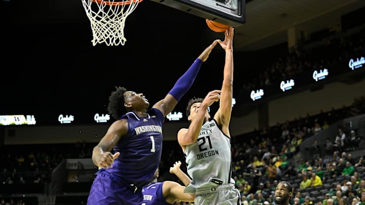 Jan 21, 2025; Eugene, Oregon, USA; Washington Huskies forward Great Osobor (1) defends a drive to the basket by Oregon Ducks forward Brandon Angel (21) during the first half at Matthew Knight Arena. Mandatory Credit: Craig Strobeck-Imagn Images