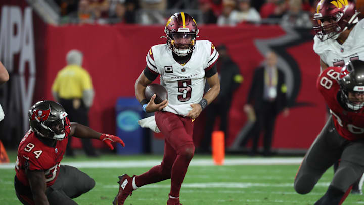 Jan 12, 2025; Tampa, Florida, USA; Washington Commanders quarterback Jayden Daniels (5) scrambles against Tampa Bay Buccaneers defensive tackle Calijah Kancey (94) during the second quarter of a NFC wild card playoff at Raymond James Stadium. Mandatory Credit: Kim Klement Neitzel-Imagn Images
