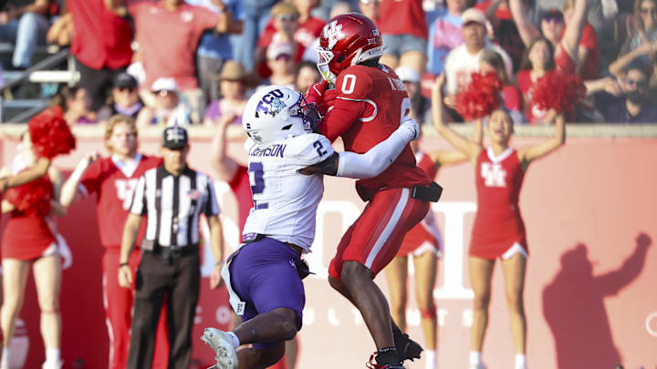 Nov 22, 2025; Houston, Texas, USA; Houston Cougars wide receiver Amare Thomas (0) makes a reception for a touchdown as TCU Horned Frogs safety Jamel Johnson (2) defends during the second quarter at TDECU Stadium. Mandatory Credit: Troy Taormina-Imagn Images