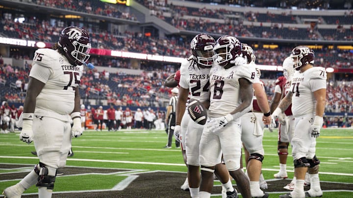 Sep 30, 2023; Arlington, Texas, USA; Texas A&M Aggies offensive lineman Kam Dewberry (75) and running back Earnest Crownover (24) and running back Le'Veon Moss (8) celebrate during the second half against the Arkansas Razorbacks at AT&T Stadium. Mandatory Credit: Jerome Miron-Imagn Images
