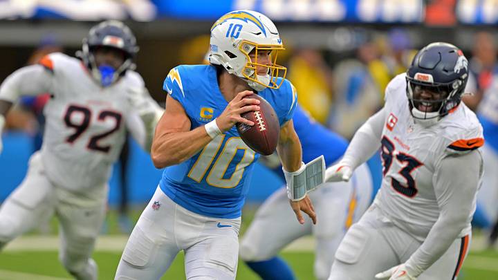 Sep 21, 2025; Inglewood, California, USA;  Los Angeles Chargers quarterback Justin Herbert (10) avoids Denver Broncos defensive tackle DJ. Jones (93) as he looks to pass in the first half at SoFi Stadium. Mandatory Credit: Jayne Kamin-Oncea-Imagn Images