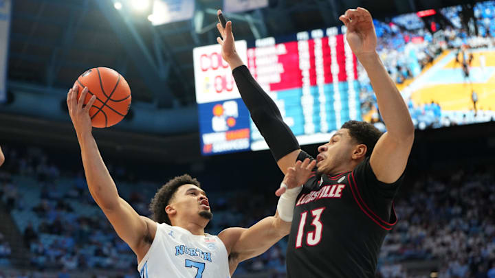 Feb 23, 2026; Chapel Hill, North Carolina, USA; North Carolina Tar Heels guard Seth Trimble (7) shoots as Louisville Cardinals forward Sananda Fru (13) defends in the second half at Dean E. Smith Center. Mandatory Credit: Bob Donnan-Imagn Images