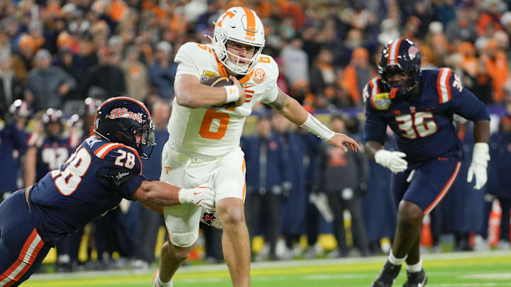Tennessee quarterback Joey Aguilar (6) runs the ball while grabbed by Illinois linebacker Dylan Rosiek (28) during the Music City Bowl NCAA college football game on Dec. 30, 2025, in Nashville, Tennessee.