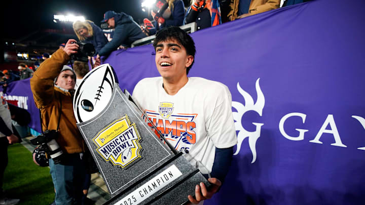 Illinois kicker David Olano (24) carries the Music City Bowl trophy after his field goal secured the win over Tennessee in an NCAA college football game on Dec. 30, 2025, in Nashville, Tennessee. Illinois kicker David Olano (24) carries the Music City Bowl trophy after his field goal secured the win over Tennessee in an NCAA college football game on Dec. 30, 2025, in Nashville, Tennessee.