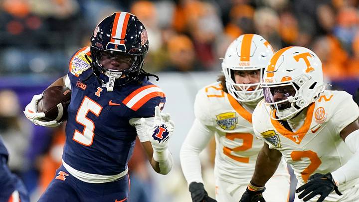 Illinois running back Ca'Lil Valentine (5) runs the ball ahead of Tennessee defensive back Andre Turrentine (2) and linebacker Jadon Perlotte (27) for a first down in the first quarter of the Music City Bowl against Tennessee in an NCAA football game on Dec. 30, 2025, in Nashville, Tennessee. Illinois running back Ca'Lil Valentine (5) runs the ball ahead of Tennessee defensive back Andre Turrentine (2) and linebacker Jadon Perlotte (27) for a first down in the first quarter of the Music City Bowl against Tennessee in an NCAA football game on Dec. 30, 2025, in Nashville, Tennessee.