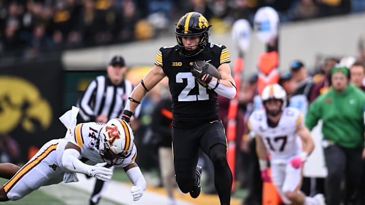 Oct 25, 2025; Iowa City, Iowa, USA; Iowa Hawkeyes wide receiver Kaden Wetjen (21) runs with the ball after a catch against Minnesota Golden Gophers defensive back Kerry Brown (14) during the first quarter at Kinnick Stadium. Mandatory Credit: Jeffrey Becker-Imagn Images