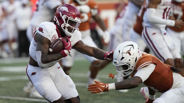 Arkansas quarterback KJ Jackson (7) runs from the pocket while defended by Texas defensive back Jelani McDonald (4) during the second half at Darrell K Royal-Texas Memorial Stadium. 