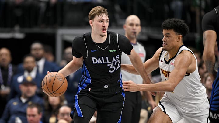Dec 23, 2025; Dallas, Texas, USA; Dallas Mavericks forward Cooper Flagg (32) looks to move the ball past Denver Nuggets forward Spencer Jones (21) during the game between the Mavericks and the Nuggets at the American Airlines Center. Mandatory Credit: Jerome Miron-Imagn Images