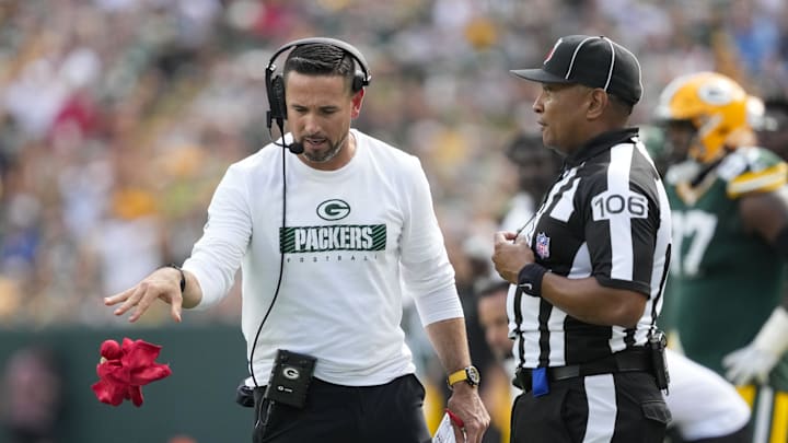 Sep 15, 2024; Green Bay, Wisconsin, USA;  Green Bay Packers head coach Matt LaFleur throws the challenge flag in front of Down Judge Patrick Holt (106) during the fourth quarter against the Indianapolis Colts at Lambeau Field. Mandatory Credit: Jeff Hanisch-Imagn Images