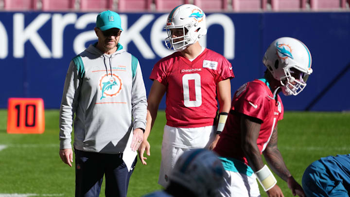 Miami Dolphins quarterback Zach Wilson (0) and quarterbacks coach Darrell Bevell watch as quarterback Tua Tagovailoa (1) takes the snap during practice at Estadio Riyadh Air Metropolitano in Spain. Miami Dolphins quarterback Zach Wilson (0) and quarterbacks coach Darrell Bevell watch as quarterback Tua Tagovailoa (1) takes the snap during practice at Estadio Riyadh Air Metropolitano in Spain.