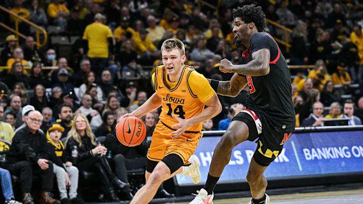 Dec 6, 2025; Iowa City, Iowa, USA; Iowa Hawkeyes guard Bennett Stirtz (14) goes to the basket as Maryland Terrapins forward Solomon Washington (9) defends during the second half at Carver-Hawkeye Arena. Mandatory Credit: Jeffrey Becker-Imagn Images