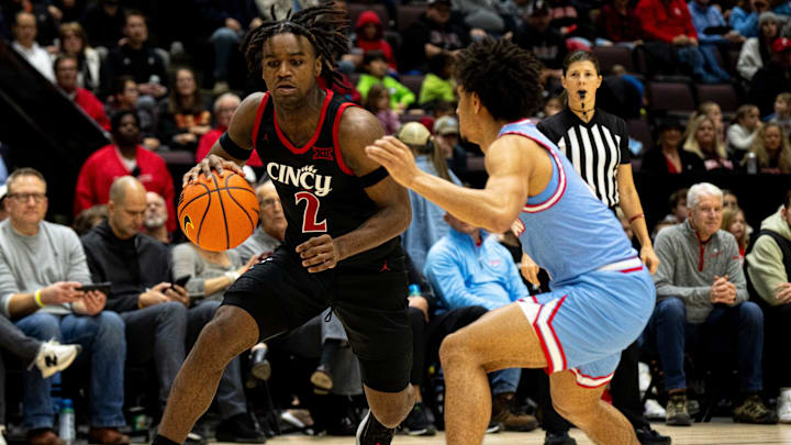 Cincinnati Bearcats guard Jizzle James (2) drives on a Dayton Flyers defender in the second half of the NCAA men's basketball game between the Dayton Flyers and Cincinnati Bearcats at Heritage Bank Center in Cincinnati on Saturday, Dec. 16, 2023. Cincinnati Bearcats guard Jizzle James (2) drives on a Dayton Flyers defender in the second half of the NCAA men's basketball game between the Dayton Flyers and Cincinnati Bearcats at Heritage Bank Center in Cincinnati on Saturday, Dec. 16, 2023.