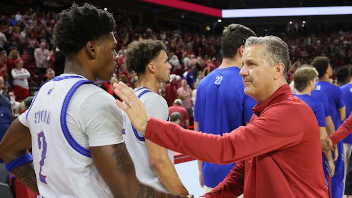 Oct 25, 2024; Fayetteville, AR, USA; Arkansas Razorbacks head coach John Calipari shakes hands with Kansas Jayhawks guard AJ Storr (2) after the game at Bud Walton Arena. Mandatory Credit: Nelson Chenault-Imagn Images