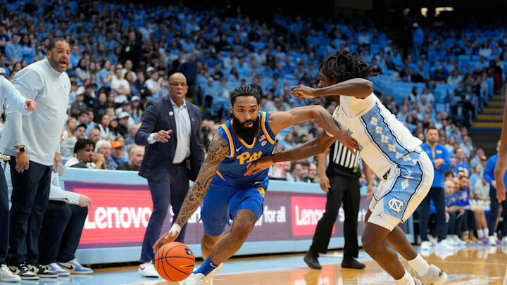 Feb 8, 2025; Chapel Hill, North Carolina, USA;  Pittsburgh Panthers guard Damian Dunn (1) dribbles as North Carolina Tar Heels guard Ian Jackson (11) defends in the first half at Dean E. Smith Center. Mandatory Credit: Bob Donnan-Imagn Images