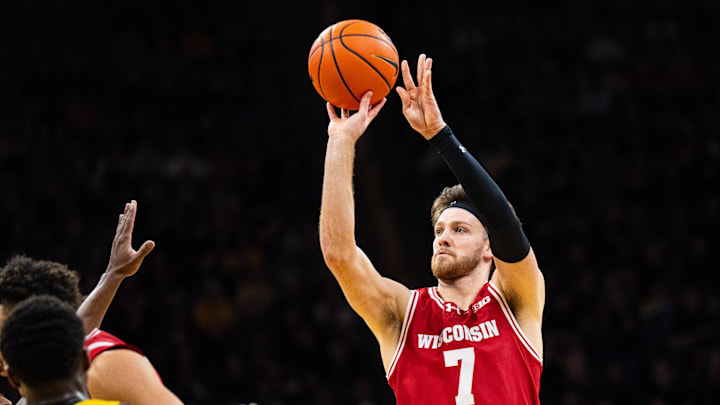 Feb 8, 2025; Iowa City, Iowa, USA; Wisconsin Badgers forward Carter Gilmore (7) shoots a three point basket against Iowa Hawkeyes forward Seydou Traore (7) during the first half at Carver-Hawkeye Arena. Mandatory Credit: Dylan Widger-Imagn Images