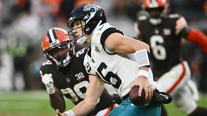 Dec 10, 2023; Cleveland, Ohio, USA; Jacksonville Jaguars quarterback Trevor Lawrence (16) scrambles from Cleveland Browns cornerback Cameron Mitchell (29) during the second half at Cleveland Browns Stadium. 
