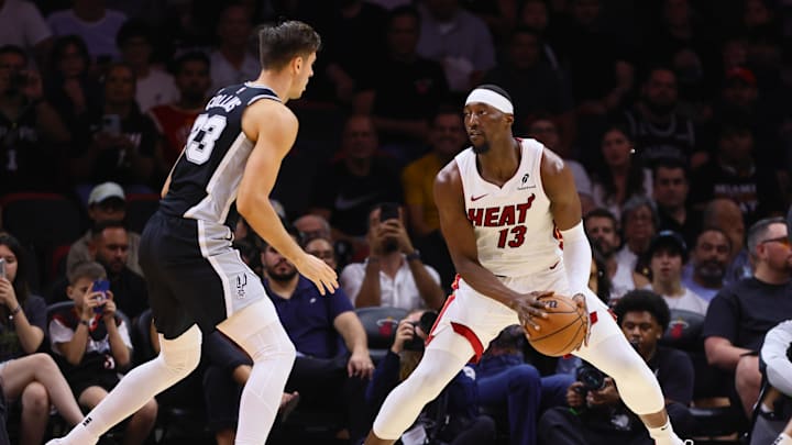 Oct 15, 2024; Miami, Florida, USA; Miami Heat center Bam Adebayo (13) controls the basketball against San Antonio Spurs forward Zach Collins (23) during the second quarter at Kaseya Center. Mandatory Credit: Sam Navarro-Imagn Images