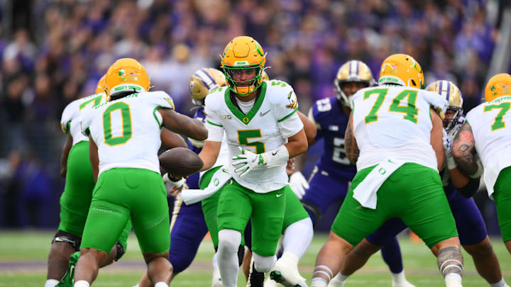 Nov 29, 2025; Seattle, Washington, USA; Oregon Ducks quarterback Dante Moore (5) hands the ball off to running back Jordon Davison (0) during the first half against the Washington Huskies at Husky Stadium. Mandatory Credit: Steven Bisig-Imagn Images Nov 29, 2025; Seattle, Washington, USA; Oregon Ducks quarterback Dante Moore (5) hands the ball off to running back Jordon Davison (0) during the first half against the Washington Huskies at Husky Stadium. Mandatory Credit: Steven Bisig-Imagn Images