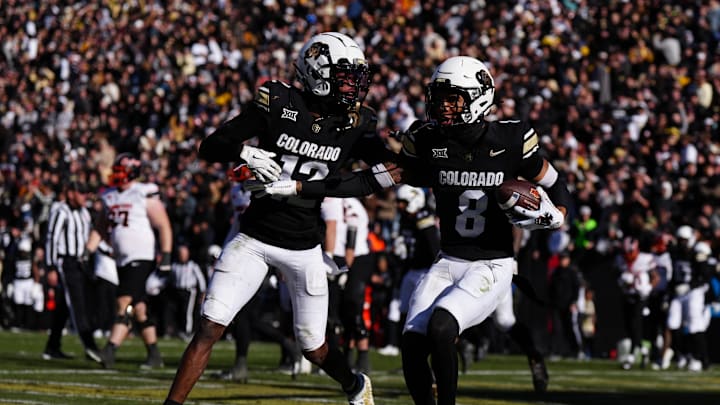Nov 29, 2024; Boulder, Colorado, USA; Colorado Buffaloes cornerback DJ McKinney (8) celebrates his interception with wide receiver Travis Hunter (12) in the second half against the Oklahoma State Cowboys at Folsom Field. Mandatory Credit: Ron Chenoy-Imagn Images