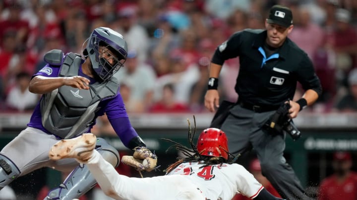 Cincinnati Reds shortstop Elly De La Cruz (44) dives across the plate to score ahead of a tag from Colorado Rockies catcher Elias Díaz (35) in the eighth inning of the MLB National League game between the Cincinnati Reds and the Colorado Rockies at Great American Ball Park in downtown Cincinnati on Monday, July 8, 2024.