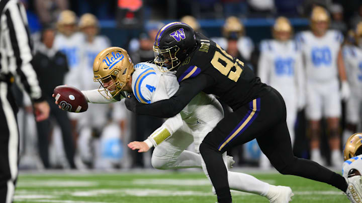 Nov 15, 2024; Seattle, Washington, USA; Washington Huskies defensive lineman Russell Davis II (99) sacks UCLA Bruins quarterback Ethan Garbers (4) during the second half at Alaska Airlines Field at Husky Stadium. Mandatory Credit: Steven Bisig-Imagn Images