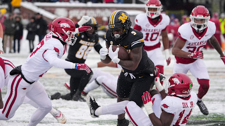 Nov 30, 2024; Columbia, Missouri, USA; Missouri Tigers running back Marcus Carroll (9) runs the ball as Arkansas Razorbacks linebacker Stephen Dix Jr. (14) attempts the tackle during the first half at Faurot Field at Memorial Stadium. Mandatory Credit: Denny Medley-Imagn Images