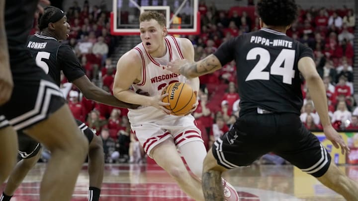 Wisconsin forward Austin Rapp (22) drives between UW-Milwaukee forward Sekou Konneh (25) and guard Esyah Pippa-White (24) during the second half of their game Tuesday, December 30, 2025 at the Kohl Center in Madison, Wisconsin. Wisconsin beat UW-Milwaukee 80-60.
