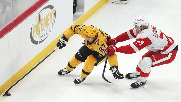 Jan 1, 2026; Pittsburgh, Pennsylvania, USA;  Pittsburgh Penguins center Sidney Crosby (87) moves the puck against Detroit Red Wings defenseman Simon Edvinsson (77) during the second period at PPG Paints Arena. Mandatory Credit: Charles LeClaire-Imagn Images