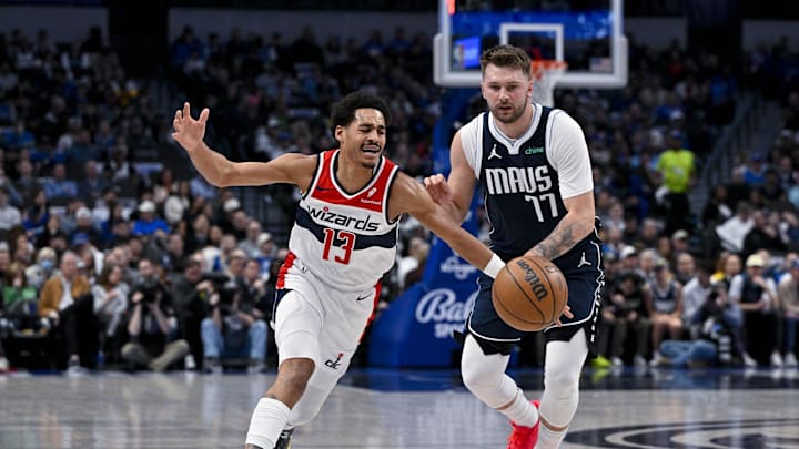 Feb 12, 2024; Dallas, Texas, USA; Washington Wizards guard Jordan Poole (13) is fouled by Dallas Mavericks guard Luka Doncic (77) during the first quarter at the American Airlines Center. Mandatory Credit: Jerome Miron-Imagn Images