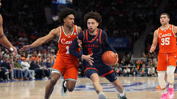 Mar 13, 2026; Charlotte, NC, USA; Virginia Cavaliers guard Sam Lewis (5) with the ball as Miami (FL) Hurricanes guard Tru Washington (10) defends in the second half at Spectrum Center. Mandatory Credit: Bob Donnan-Imagn Images