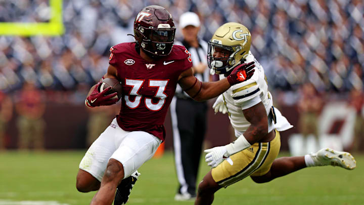 Oct 26, 2024; Blacksburg, Virginia, USA; Virginia Tech Hokies running back Bhayshul Tuten (33) runs the ball against Georgia Tech Yellow Jackets defensive back Clayton Powell-Lee (5) during the second quarter at Lane Stadium. Mandatory Credit: Peter Casey-Imagn Images