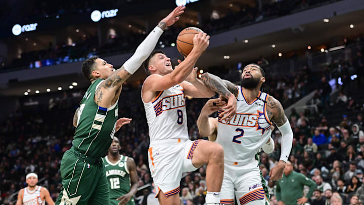 Apr 1, 2025; Milwaukee, Wisconsin, USA; Phoenix Suns guard Grayson Allen (8) takes a shot against Milwaukee Bucks forward Kyle Kuzma (18) in the second quarter at Fiserv Forum. Mandatory Credit: Benny Sieu-Imagn Images