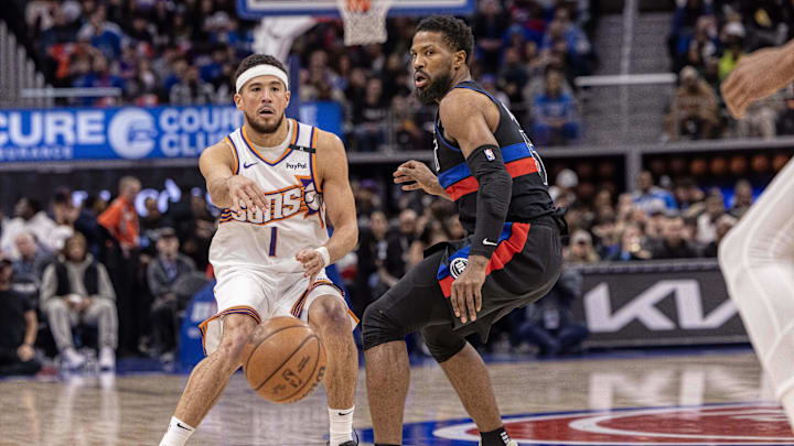 Phoenix Suns guard Devin Booker passes the ball against Detroit Pistons guard Malik Beasley. Phoenix Suns guard Devin Booker passes the ball against Detroit Pistons guard Malik Beasley.
