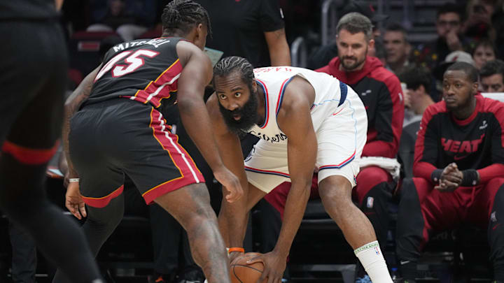 Mar 12, 2025; Miami, Florida, USA;  LA Clippers guard James Harden (1) looks to pass against Miami Heat guard Davion Mitchell (45) defends during the first half at Kaseya Center. Mandatory Credit: Jim Rassol-Imagn Images