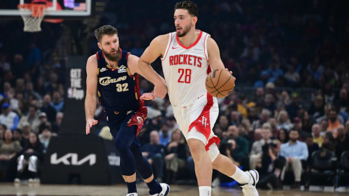 Nov 19, 2025; Cleveland, Ohio, USA; Houston Rockets center Alperen Sengun (28) dribbles ahead of Cleveland Cavaliers forward Dean Wade (32) during the first half at Rocket Arena. Mandatory Credit: David Dermer-Imagn Images