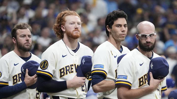Milwaukee Brewers pitcher Dustin May (21), designated hitter Christian Yelich (22), and pitcher Aaron Ashby (26) stand for the National Anthem prior to game one of the NLCS for the 2026 MLB Playoffs against the Los Angeles Dodgers at American Family Field. Milwaukee Brewers pitcher Dustin May (21), designated hitter Christian Yelich (22), and pitcher Aaron Ashby (26) stand for the National Anthem prior to game one of the NLCS for the 2026 MLB Playoffs against the Los Angeles Dodgers at American Family Field.