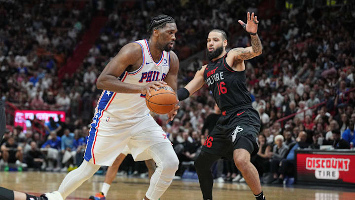 Apr 4, 2024; Miami, Florida, USA;  Philadelphia 76ers center Joel Embiid (21) drives past Miami Heat forward Caleb Martin (16) during the second half at Kaseya Center. Mandatory Credit: Jim Rassol-Imagn Images