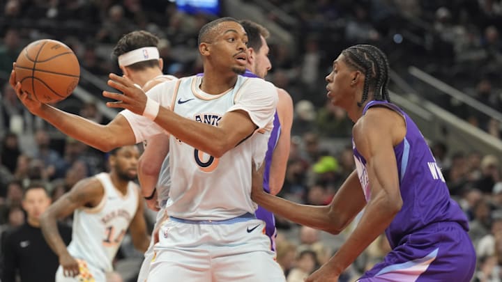Nov 21, 2024; San Antonio, Texas, USA; San Antonio Spurs forward Keldon Johnson (0) looks to pass the ball while defended by Utah Jazz forward Cody Williams (5) during the first half at Frost Bank Center. Mandatory Credit: Scott Wachter-Imagn Images