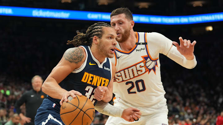 Dec 25, 2024; Phoenix, Arizona, USA; Denver Nuggets forward Aaron Gordon (32) dribbles against Phoenix Suns center Jusuf Nurkic (20) during the second half at Footprint Center. Mandatory Credit: Joe Camporeale-Imagn Images
