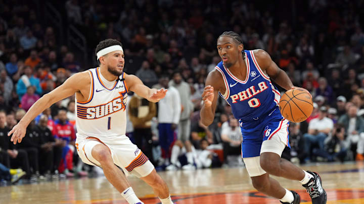 Nov 4, 2024; Phoenix, Arizona, USA; Philadelphia 76ers guard Tyrese Maxey (0) dribbles against Phoenix Suns guard Devin Booker (1) during the second half at Footprint Center. Mandatory Credit: Joe Camporeale-Imagn Images